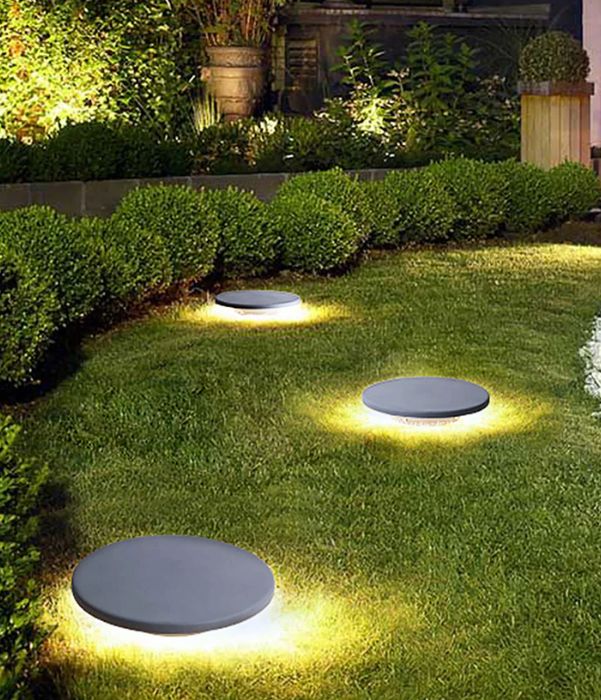 Softly glowing outdoor lights in a garden, enhancing the beauty of plants and pathways during the evening.